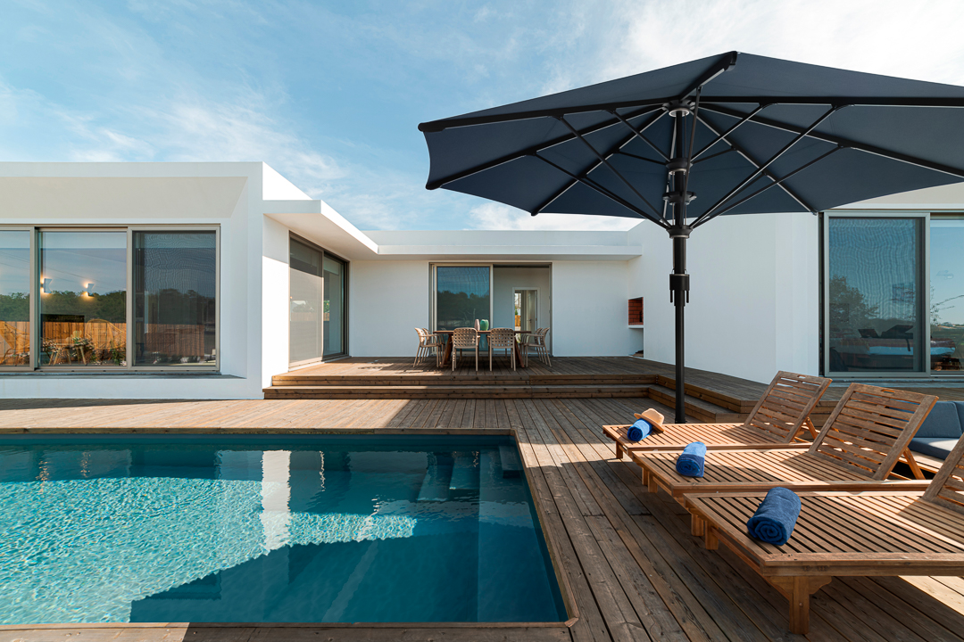 Wooden,Lounge,Chairs,In,Modern,Villa,Pool,And,Deck